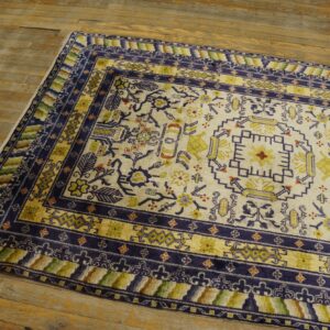 Medium pile cream and navy rug featuring traditional patterns sits on rustic, wide plank wood flooring.