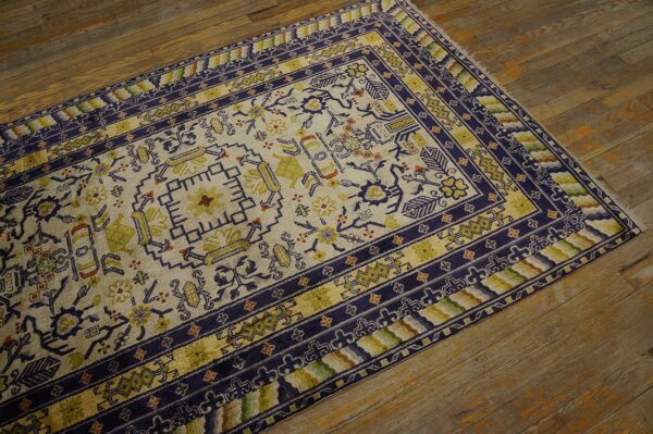Cream rug featuring geometric and floral designs in deep blue and chartreuse colors on wood planks.