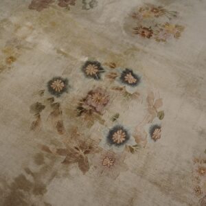 Low-pile beige rug with faded appearance features large floral medallions in soft pastels and cool gray.