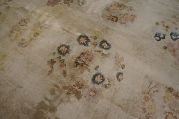 Low-pile beige rug with faded appearance features large floral medallions in soft pastels and cool gray.