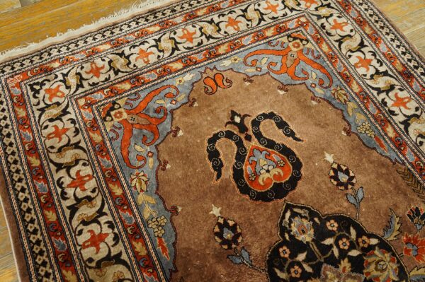 Ornate brown rug with detailed rust and blue gray borders rests on distressed wood flooring.