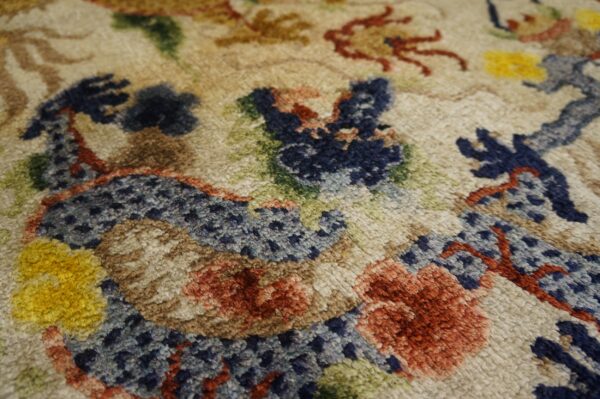 High pile rug texture showing abstract design elements in beige, navy, rust, brown, green, and yellow.