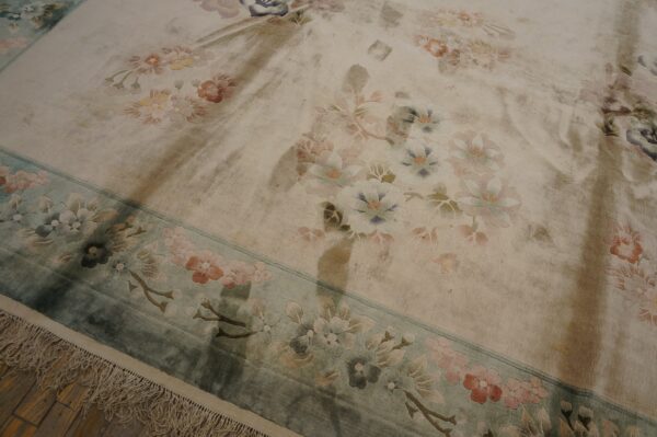 Vintage light cream color european influenced florals luxurious silk pile chinese room size rug 5 Muted floral rug with a carved cream field and teal border displays soft pile and fringes on dark wood.