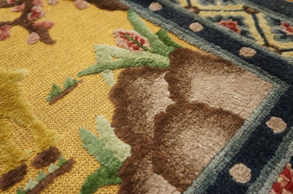High-low pile rug detail showing a bright gold flat field contrasting with raised brown, green, and blue patterns.