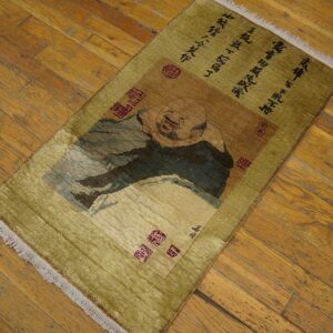 Low pile rug in olive and brown features a portrait panel and black text on wood floorboards.