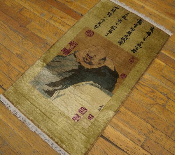 Low pile rug in olive and brown features a portrait panel and black text on wood floorboards.