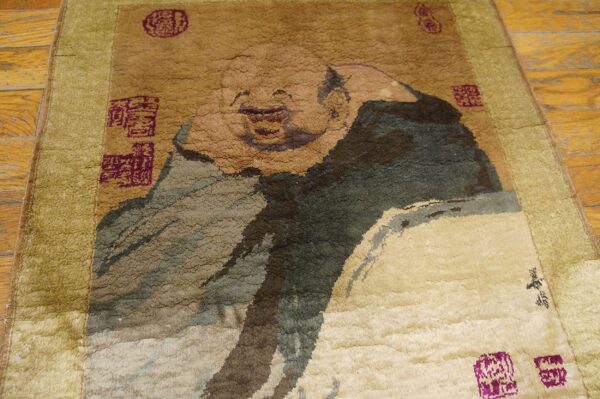 Textured brown and olive rug featuring a large laughing figure motif and purple square seals on wood floor.