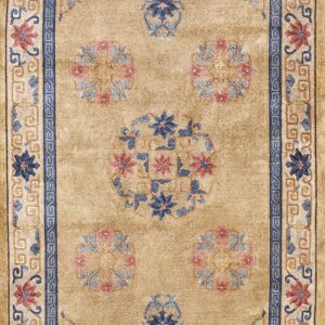 Traditional tan rug with blue and pink floral medallions surrounded by detailed scrolling borders.