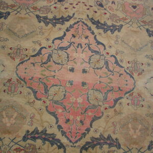 Faded low-pile rug showing a pink central medallion and blue scrolling florals on a light beige field.