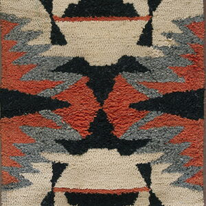 A thick looped rug featuring a geometric pattern in cream, black, gray, and burnt orange.