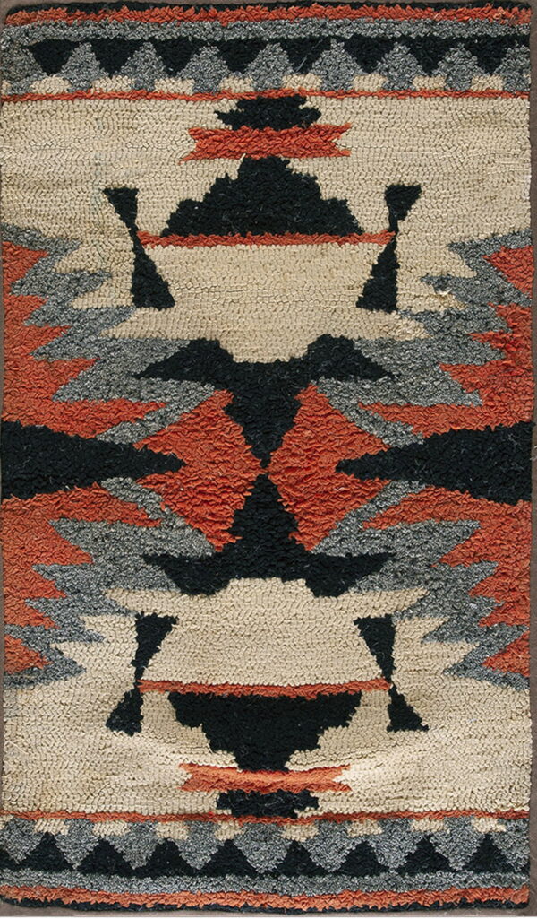 A thick looped rug featuring a geometric pattern in cream, black, gray, and burnt orange.