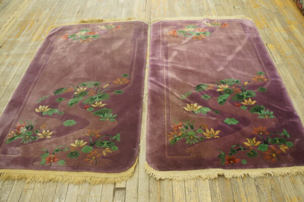 Matching high-pile dusty purple runners with carved yellow and orange floral patterns on light wooden planks.