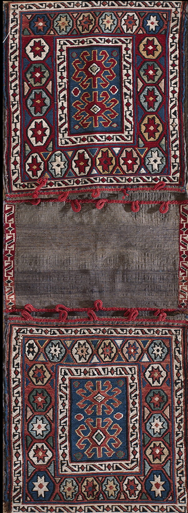 A long vertical textile featuring two geometric red, blue, and cream panels separated by a plain dark gray center.