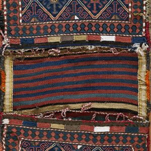 Complex geometric textile featuring navy and terracotta pile sections joined by a center striped flatwoven band.