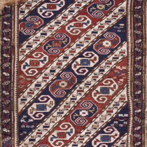 Flatwoven rug featuring diagonal stripes in red, navy blue, and cream with complex geometric motifs.