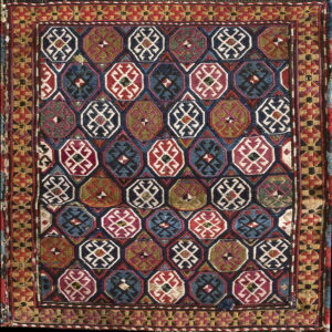 Low pile geometric rug with repeating octagonal motifs in red, blue, green, and cream, surrounded by a complex border.