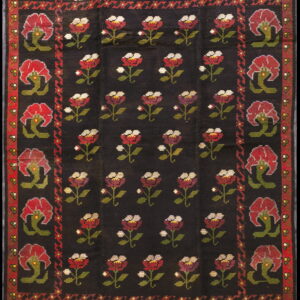 Black rug with a repeating pattern of red and white stemmed flowers and a broad red floral border.