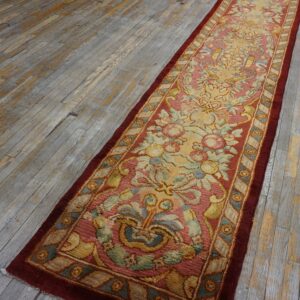Ornate floral runner in rose, yellow, and sage green rests on rustic gray-toned wood planks.
