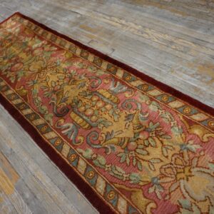 Ornate floral runner rug in rose, gold, and green rests on rustic gray wood plank flooring.