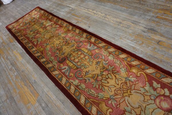 Ornate floral runner rug in rose, gold, and green rests on rustic gray wood plank flooring.