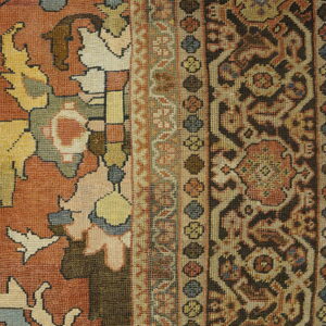 Rust, brown, beige, and blue rug detail showing an abstract field and complex patterned borders.