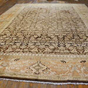 Low-pile rug with a dark brown field, beige florals, and wide gold/tan decorative borders on wood.