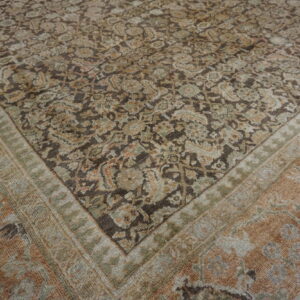 Muted traditional rug with a dense brown and beige floral pattern bordered by peach and olive bands.