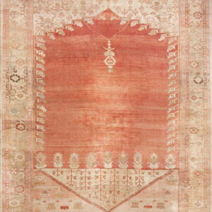 Distressed low-pile rug with a salmon prayer niche design bordered by intricate pale beige florals.