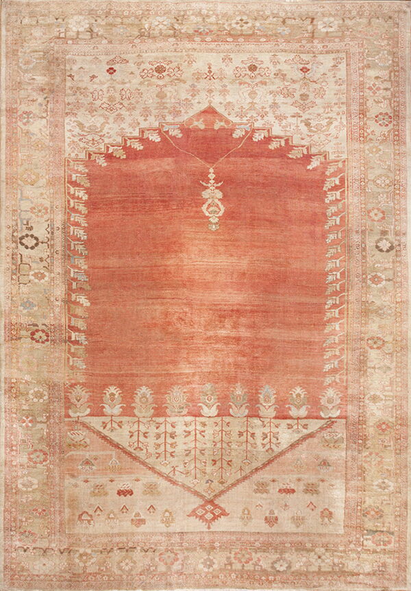 Distressed low-pile rug with a salmon prayer niche design bordered by intricate pale beige florals.