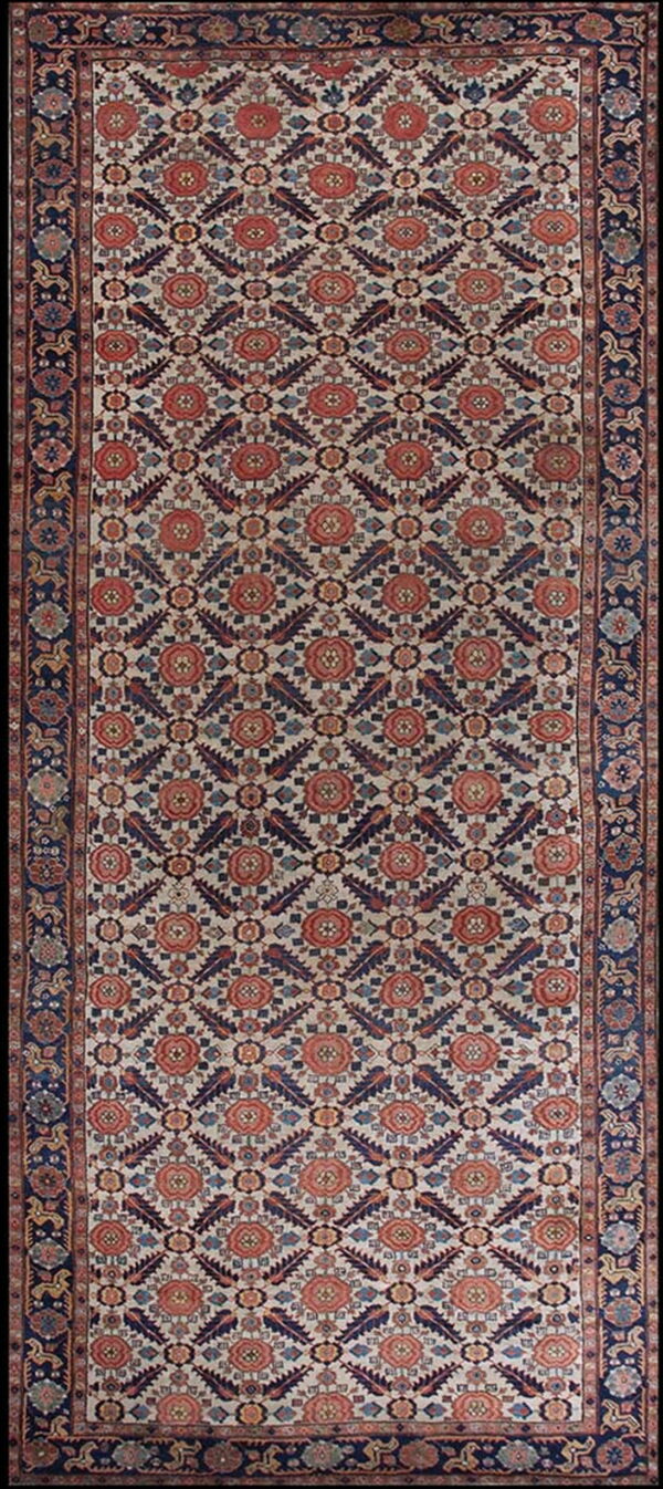 Cream, navy, and rust-colored runner rug with dense floral geometric designs and a wide dark border.