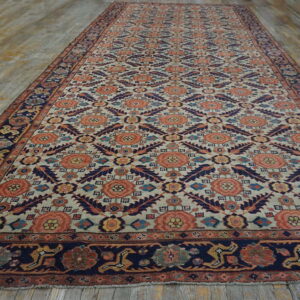 A long rug featuring coral and navy geometric and floral patterns on a pale background over wood flooring.