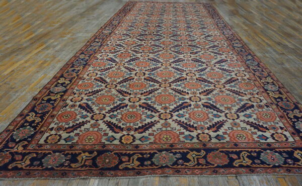A long rug featuring coral and navy geometric and floral patterns on a pale background over wood flooring.