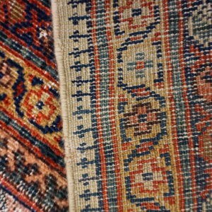 Two rugs side by side show contrasting textures and geometric patterns in red, navy, beige, and teal.