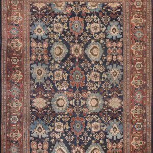 Traditional navy blue and light blue medallion pattern rug with a wide rust red ornamental border.