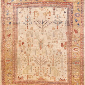 Beige rug with a tribal tree pattern and golden tan borders featuring abstract floral designs in red and blue.