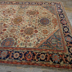 Intricate low-pile floral rug featuring cream, rust, and navy blue, resting on wide weathered wooden planks.