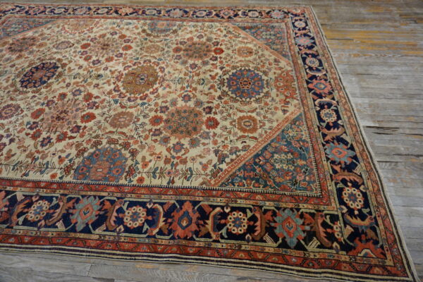 Intricate low-pile floral rug featuring cream, rust, and navy blue, resting on wide weathered wooden planks.