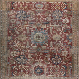 Low pile rug with a faded red field and elaborate floral designs in blue, tan, and cream.