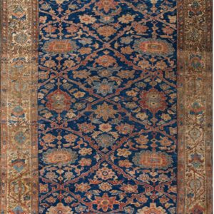 Dark blue rug with faded terracotta and gold botanical patterns, surrounded by a complex tan border.