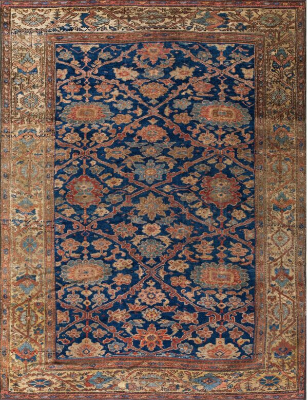 Dark blue rug with faded terracotta and gold botanical patterns, surrounded by a complex tan border.