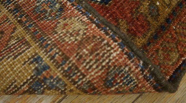 A close-up shows the flatwoven multicolored rug backing and the thick rust, gold, and brown pile on wood flooring.