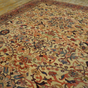 Traditional low-pile rug featuring a dense floral design in muted red, blue, and cream on a wood floor.