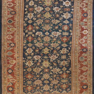Traditional blue rug with densely patterned floral motifs and a prominent red-orange multiple border.