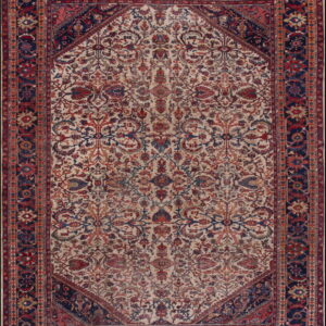 Cream rug with an elaborate red and blue floral pattern, framed by dark navy spandrels and border.