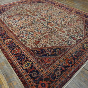 Traditional cream rug with a dense all-over floral pattern and multi-layered navy and red border on wood.