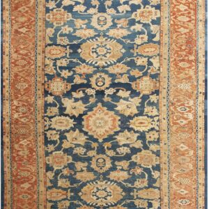 Traditional rug with a deep blue field, beige floral motifs, and a wide rust orange border.