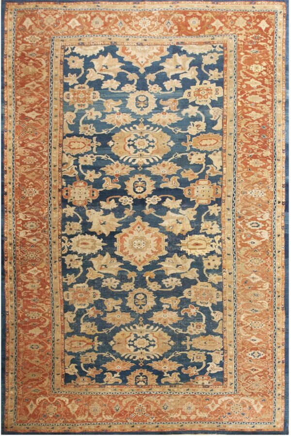 Traditional rug with a deep blue field, beige floral motifs, and a wide rust orange border.