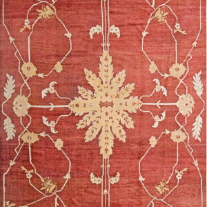 Terracotta rug with an elaborate beige central motif framed by delicate scrolling floral designs.