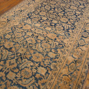 Distressed blue and tan traditional runner rug lies across glossy, medium-toned hardwood flooring.