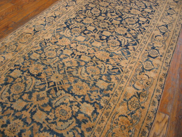 Distressed blue and tan traditional runner rug lies across glossy, medium-toned hardwood flooring.